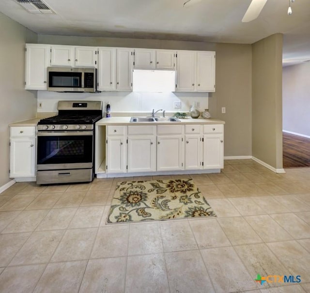 3207 Linda Dr, Victoria, TX 77901 - kitchen with appliances with stainless steel finishes, light tile patterned flooring, white cabinets, light countertops, and a ceiling fan