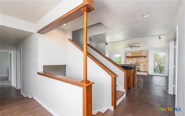 525 Teague Dr, Moody, TX 76557 - stairway with a large fireplace, track lighting, wood finished floors, a ceiling fan, and a textured ceiling