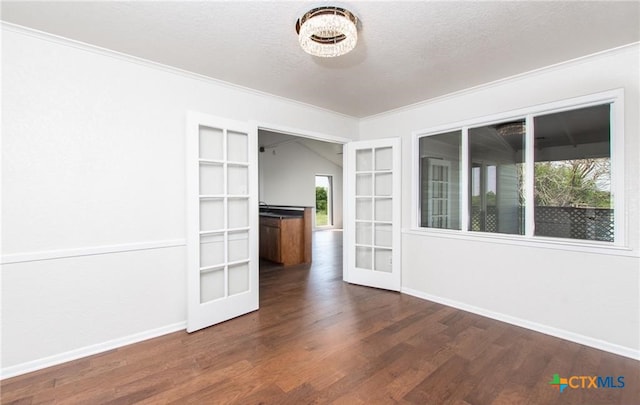 525 Teague Dr, Moody, TX 76557 - spare room with dark wood-type flooring, ornamental molding, a textured ceiling, baseboards, and french doors