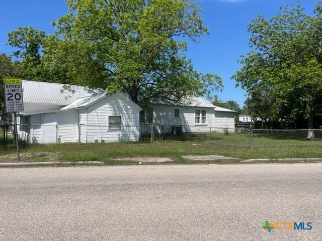 ranch-style home with metal roof and fence