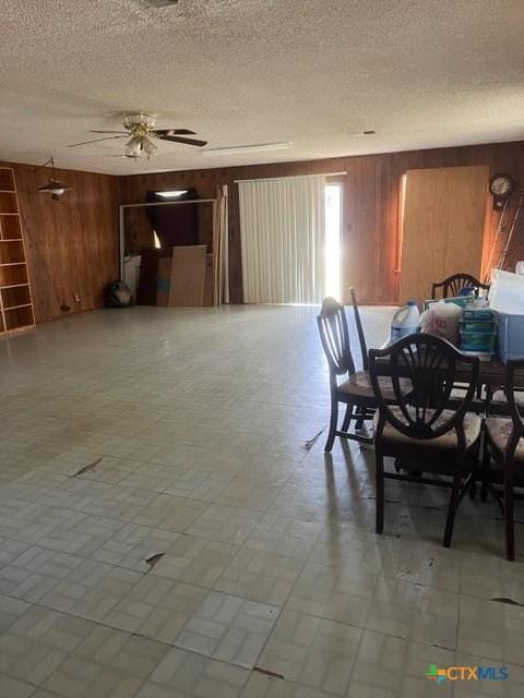 dining room with wood walls and a textured ceiling