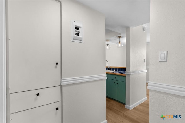 7801 Shoal Creek Blvd Unit 240, Austin, TX 78757 - kitchen with green cabinetry, light wood-style floors, and baseboards