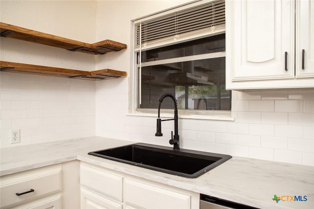 1004 Estes Dr, Killeen, TX 76541 - kitchen with light stone countertops, a sink, open shelves, tasteful backsplash, and white cabinetry