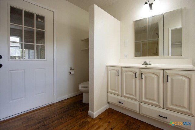 1004 Estes Dr, Killeen, TX 76541 - bathroom featuring wood-type flooring, toilet, vanity, and baseboards