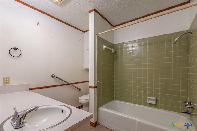 full bathroom with crown molding, vanity, a textured ceiling, toilet, and tiled shower / bath