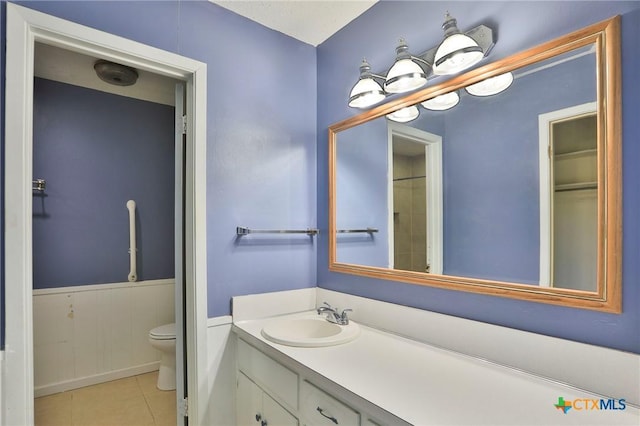 bathroom featuring vanity, toilet, and tile patterned flooring