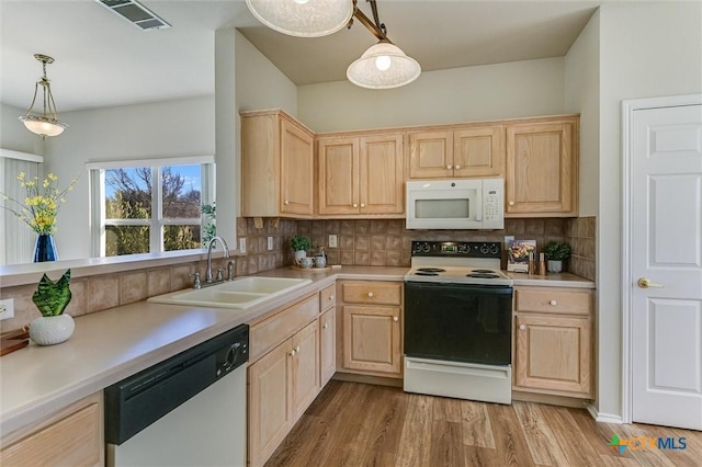 kitchen with range with electric cooktop, light brown cabinetry, decorative light fixtures, sink, and stainless steel dishwasher