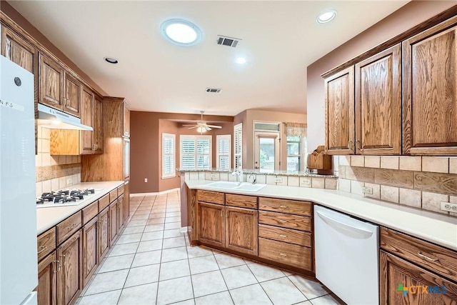 109 Ranch House Cv, Georgetown, TX 78633 - kitchen with white appliances, a sink, under cabinet range hood, tasteful backsplash, and light tile patterned flooring
