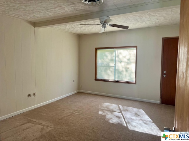 carpeted spare room featuring a textured ceiling, ceiling fan, and beam ceiling