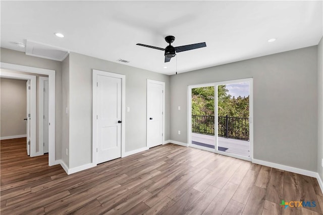 594 E S St, New Braunfels, TX 78130 - unfurnished bedroom with access to outside, wood finished floors, ceiling fan, recessed lighting, and two closets