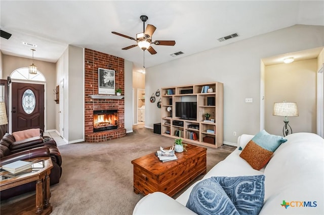 carpeted living area with a brick fireplace, visible vents, and ceiling fan