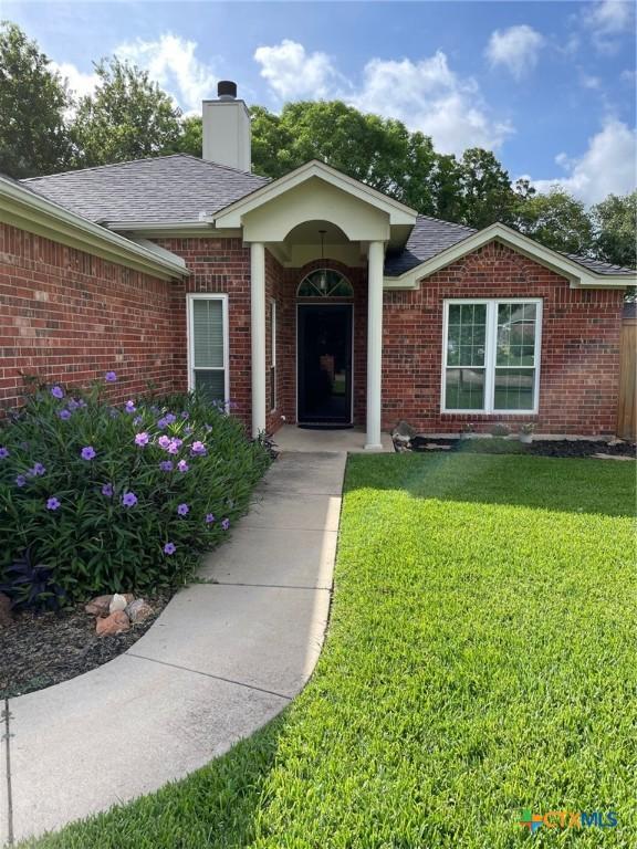 4605 Danbury Dr, Temple, TX 76502 - property entrance featuring a yard, brick siding, and a shingled roof