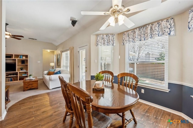 dining room featuring lofted ceiling, ceiling fan, baseboards, and wood finished floors