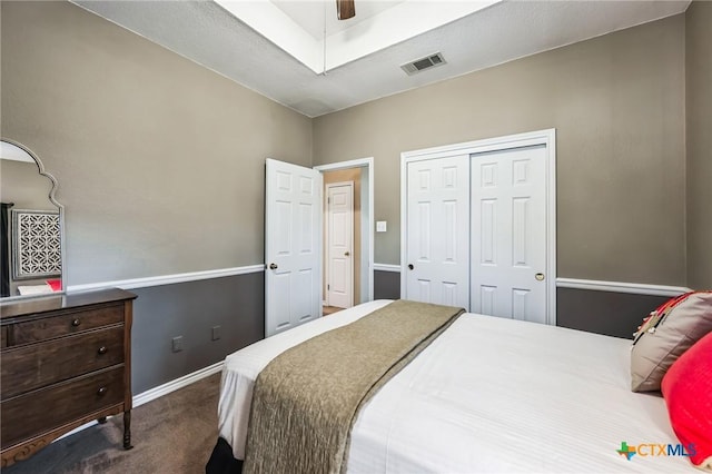 bedroom with dark colored carpet, a closet, visible vents, a ceiling fan, and baseboards