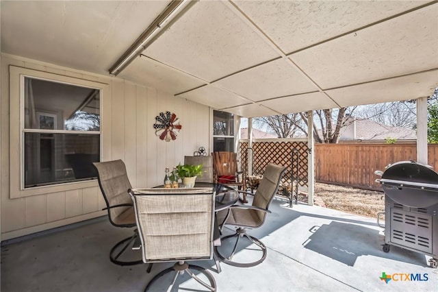 view of patio / terrace with outdoor dining space, fence, and a grill