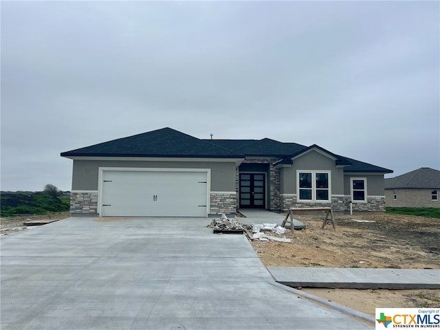 109 Carmine Ave, Port Lavaca, TX 77979 - prairie-style home featuring stone siding, stucco siding, and concrete driveway