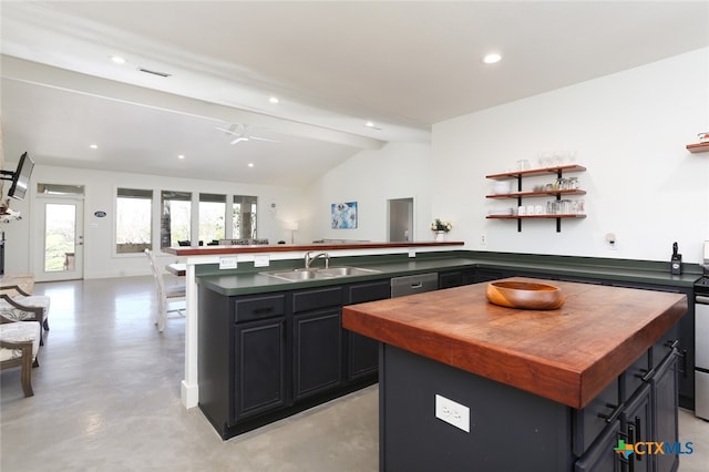 kitchen with ceiling fan, dishwasher, sink, vaulted ceiling with beams, and a kitchen island