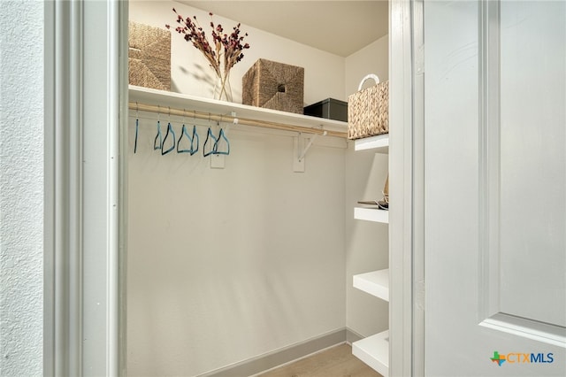 walk in closet with hardwood / wood-style flooring