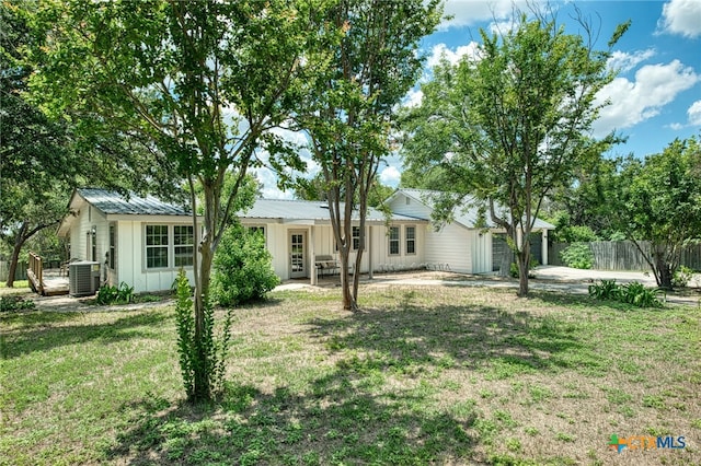 back of property with a lawn and cooling unit