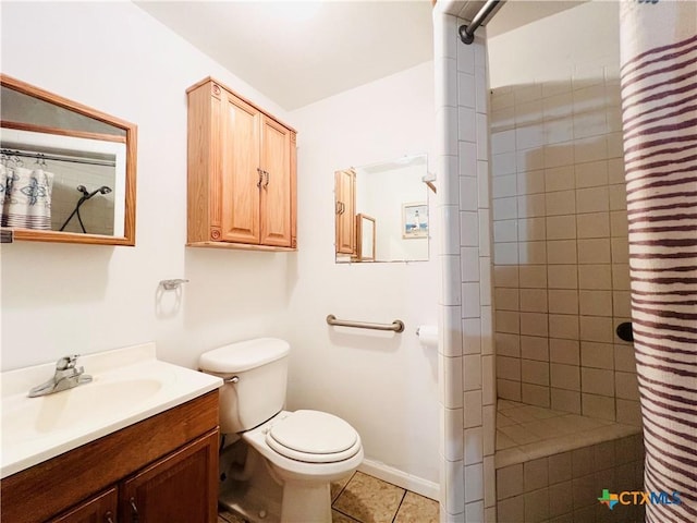 bathroom featuring toilet, a tile shower, vanity, and tile patterned floors