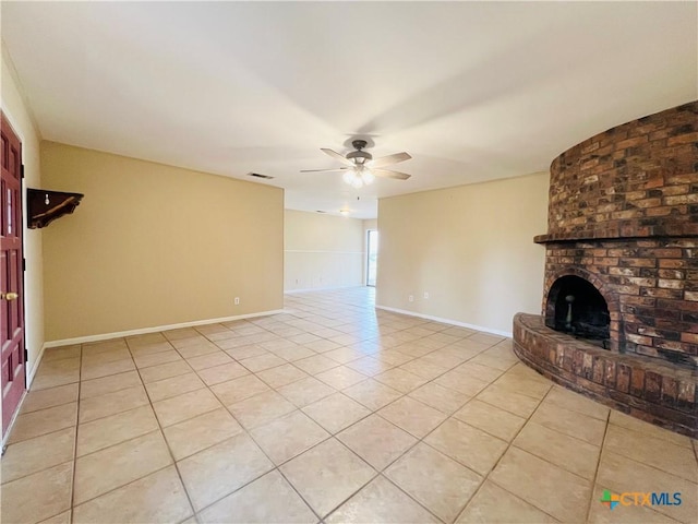 unfurnished living room with a fireplace, light tile patterned floors, and ceiling fan