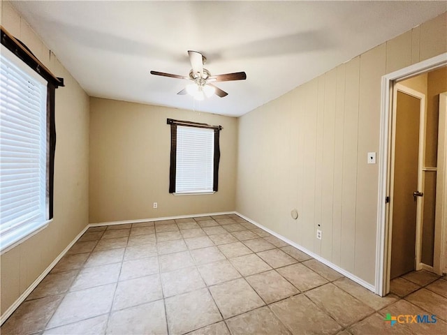 empty room featuring ceiling fan and light tile patterned flooring