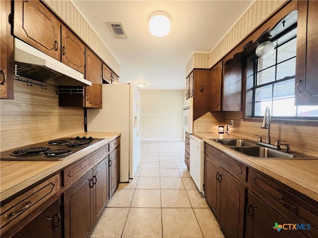 kitchen featuring decorative backsplash, white appliances, light tile patterned flooring, and sink