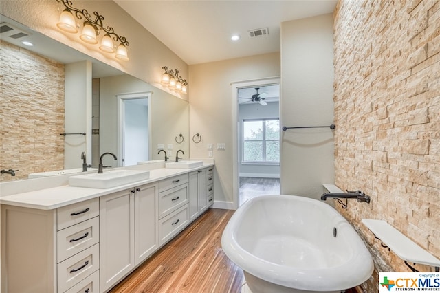 bathroom featuring vanity, a tub, hardwood / wood-style flooring, and ceiling fan