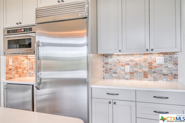 kitchen with appliances with stainless steel finishes and decorative backsplash