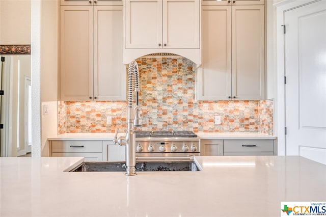 kitchen featuring high end stove and tasteful backsplash