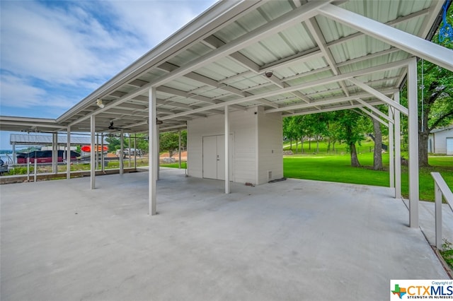 view of parking / parking lot with a lawn and a carport