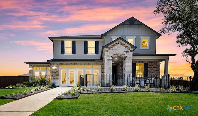 view of front of property featuring french doors and a yard