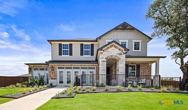 view of front of property featuring a front yard and french doors