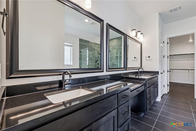 1516 Dancing Oak Ln, San Marcos, TX 78666 - bathroom featuring tile patterned floors, double vanity, a tile shower, a spacious closet, and recessed lighting