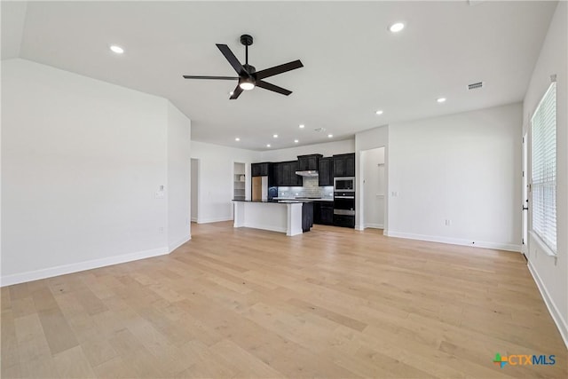 1516 Dancing Oak Ln, San Marcos, TX 78666 - unfurnished living room featuring ceiling fan, plenty of natural light, baseboards, recessed lighting, and light wood-style flooring
