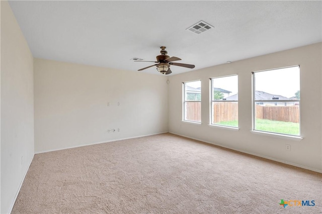 spare room featuring carpet flooring, a ceiling fan, baseboards, and visible vents