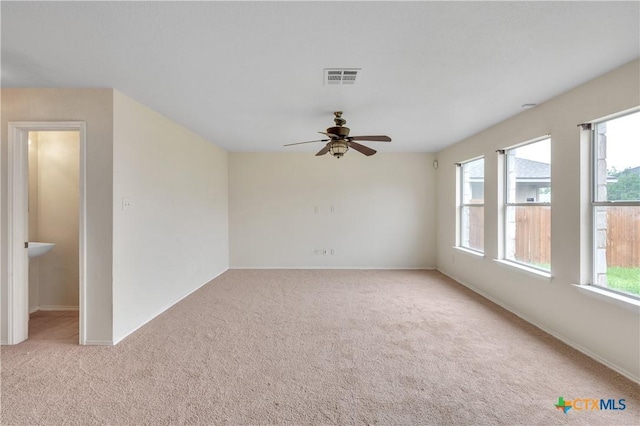 spare room featuring baseboards, carpet, a ceiling fan, and visible vents