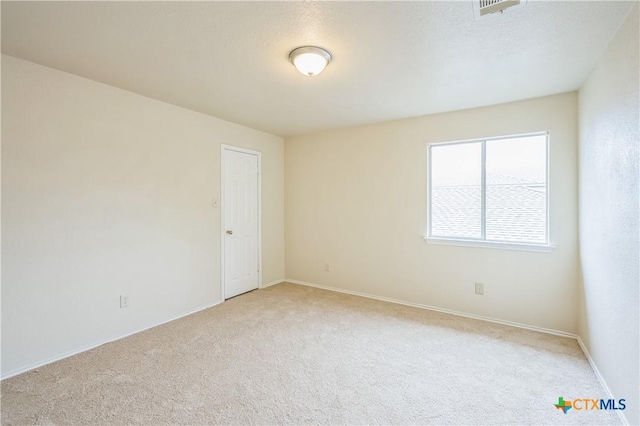 unfurnished room featuring carpet floors, baseboards, and visible vents