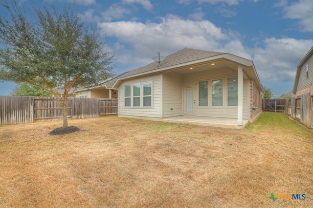 back of house featuring a patio area and a lawn