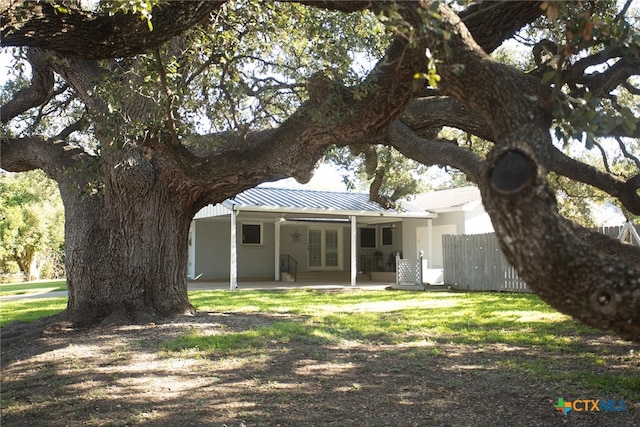 rear view of property featuring a patio area and a yard