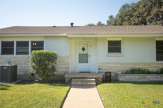 view of front of property featuring a front lawn and central air condition unit