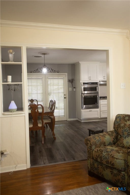 living room with dark hardwood / wood-style flooring and crown molding