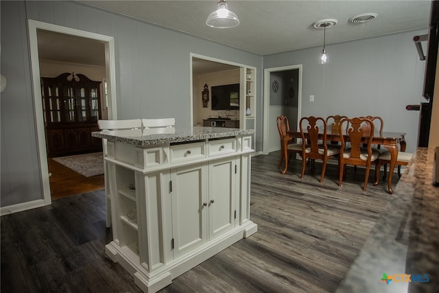 kitchen featuring dark hardwood / wood-style floors, pendant lighting, and a kitchen island