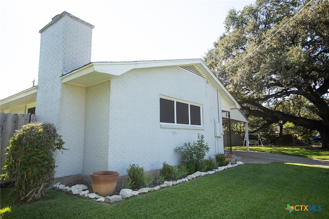 view of side of home featuring a lawn