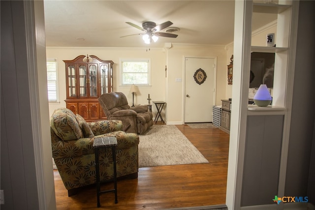 living room with ornamental molding, ceiling fan, and dark hardwood / wood-style floors