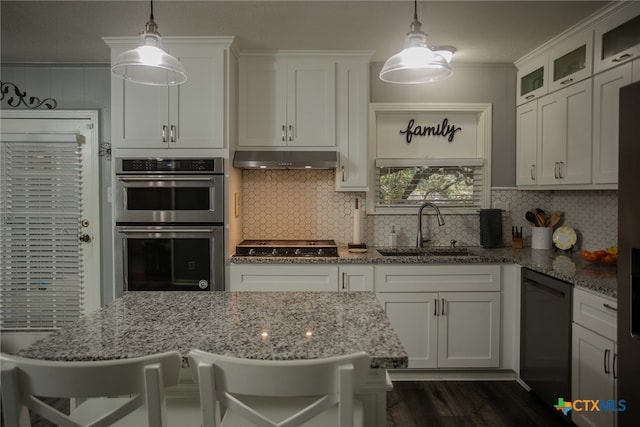 kitchen featuring black appliances, sink, pendant lighting, and a breakfast bar area