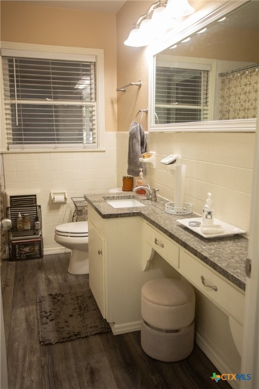 bathroom featuring tile walls, wood-type flooring, toilet, and vanity