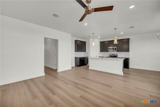 kitchen featuring sink, a center island with sink, dishwasher, pendant lighting, and white cabinets