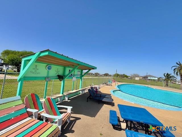 pool with fence and a patio area