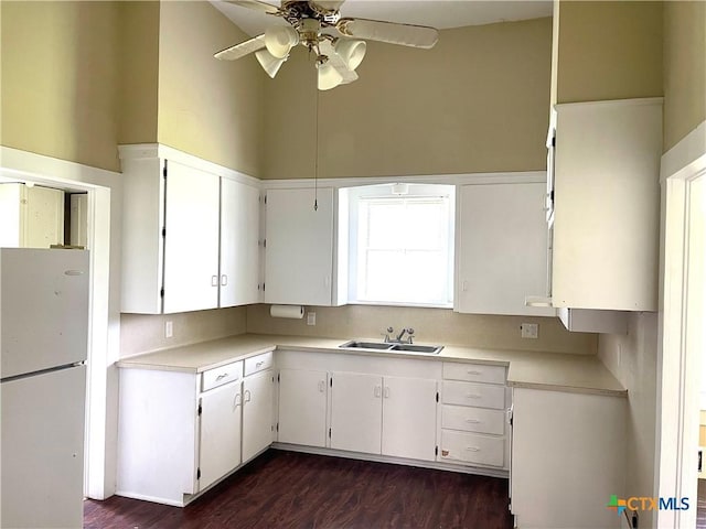 114 N Market St, Goliad, TX 77963 - kitchen featuring freestanding refrigerator, a ceiling fan, light countertops, and white cabinets